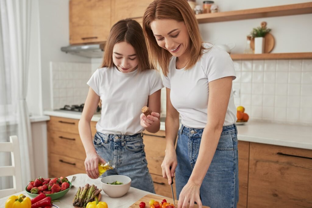 Happy mother and daughter cooking together in kitchen