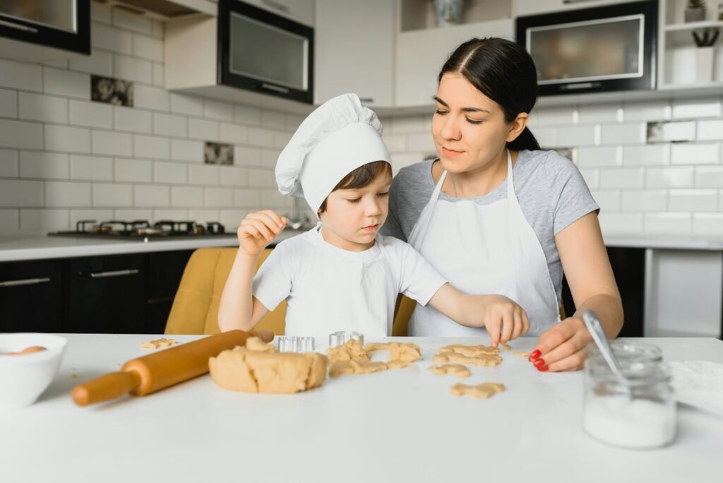 Young mother and son in kitchen making cookies.